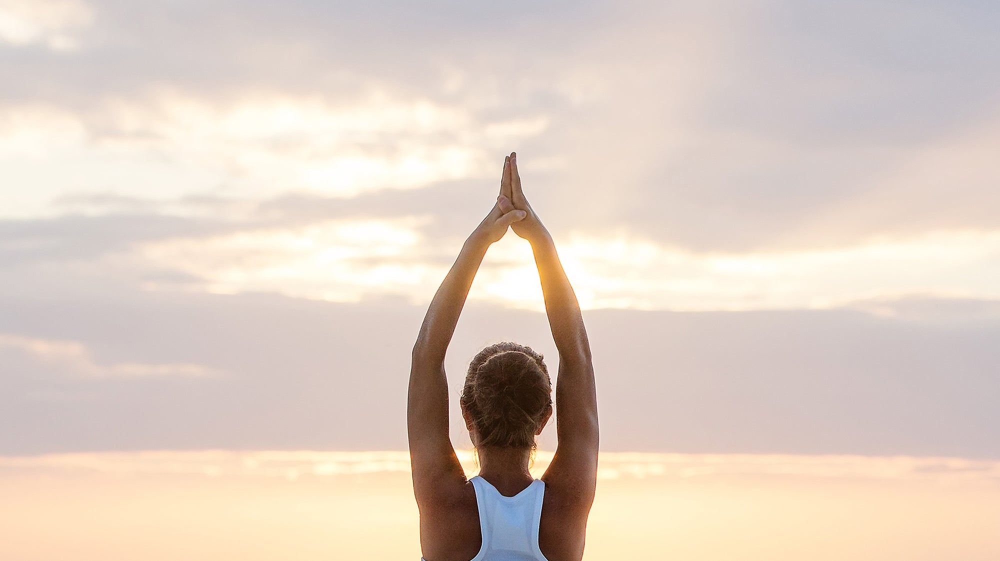 Young Woman practicing yoga on a beach