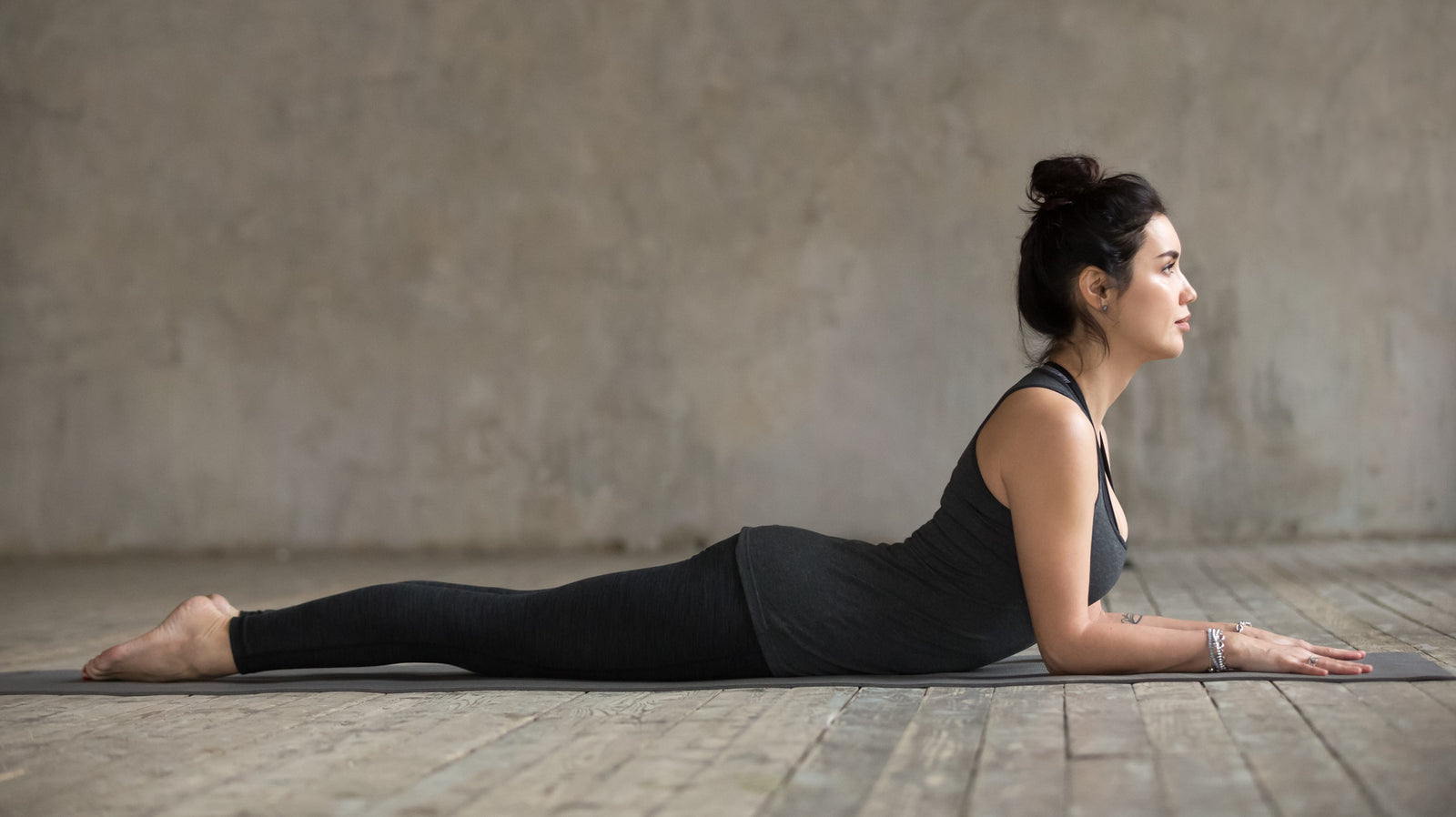Lady practicing the yoga posture bhujangasana, the cobra pose.