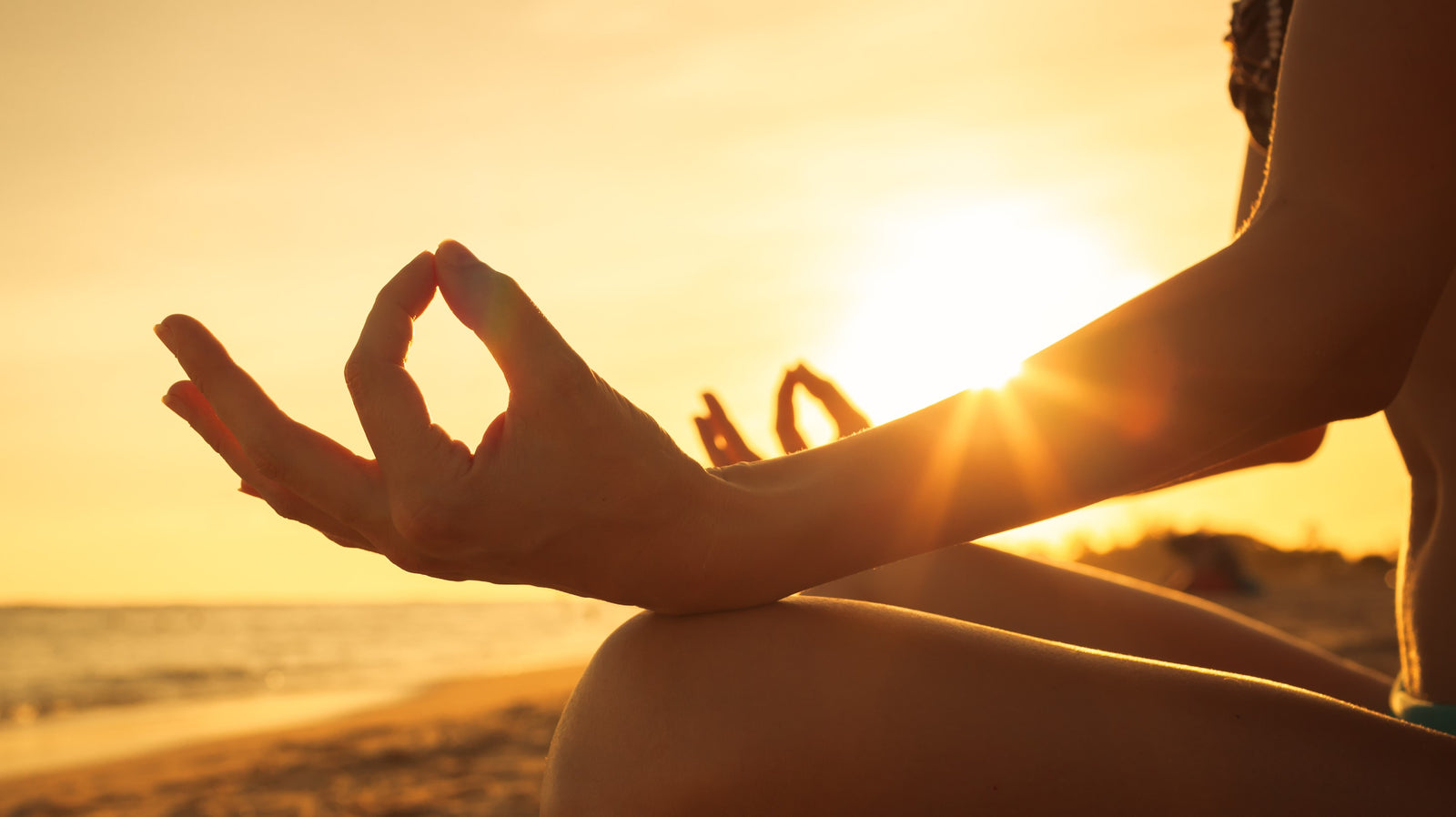 Person meditating at sunrise