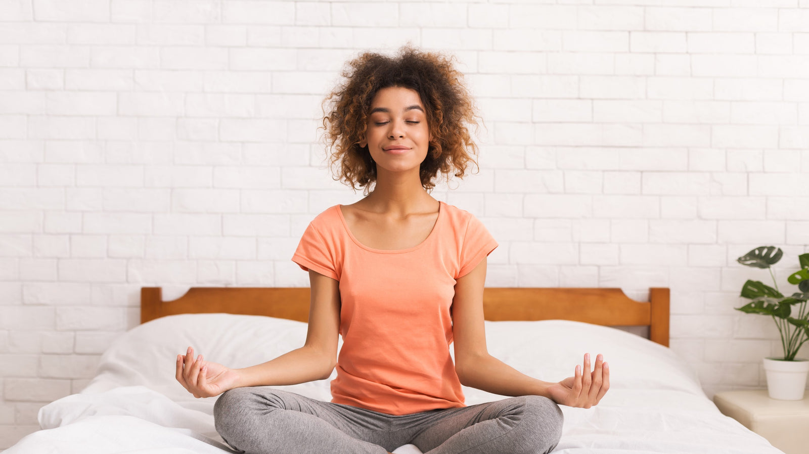 healthy lady practicing yoga on a bed