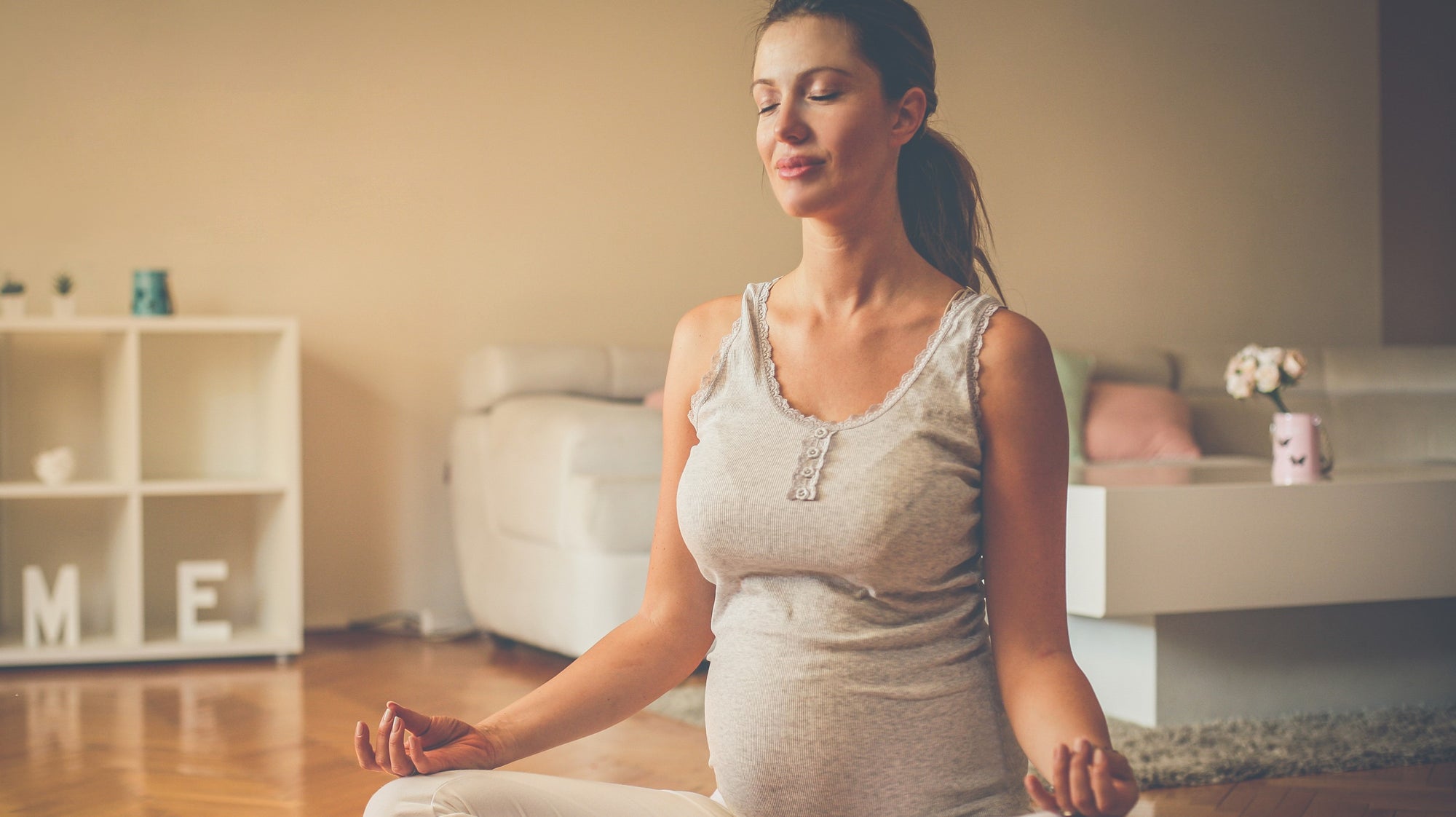 Pregnant lady practicing yoga at home