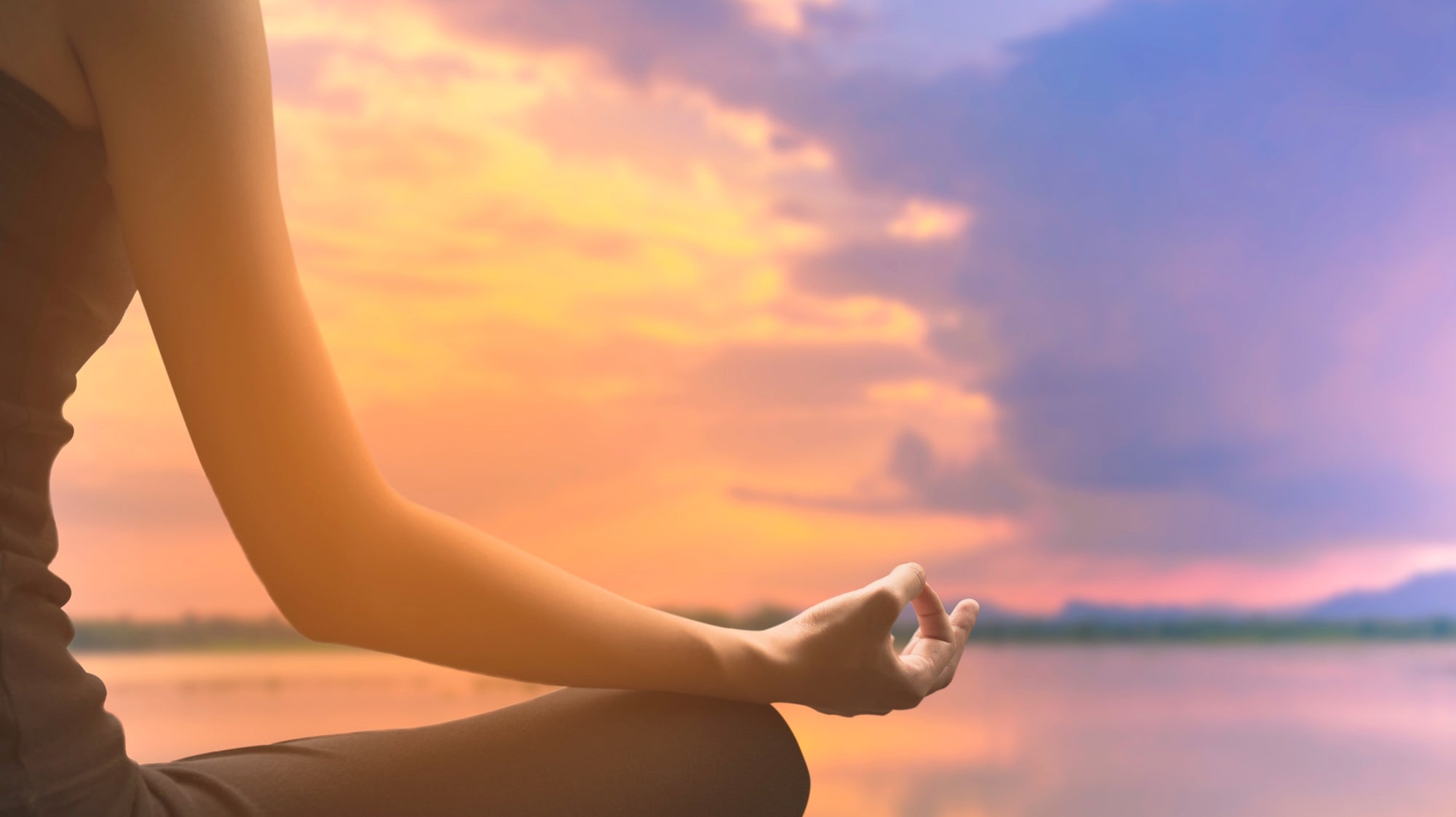 Person meditating at Sunset