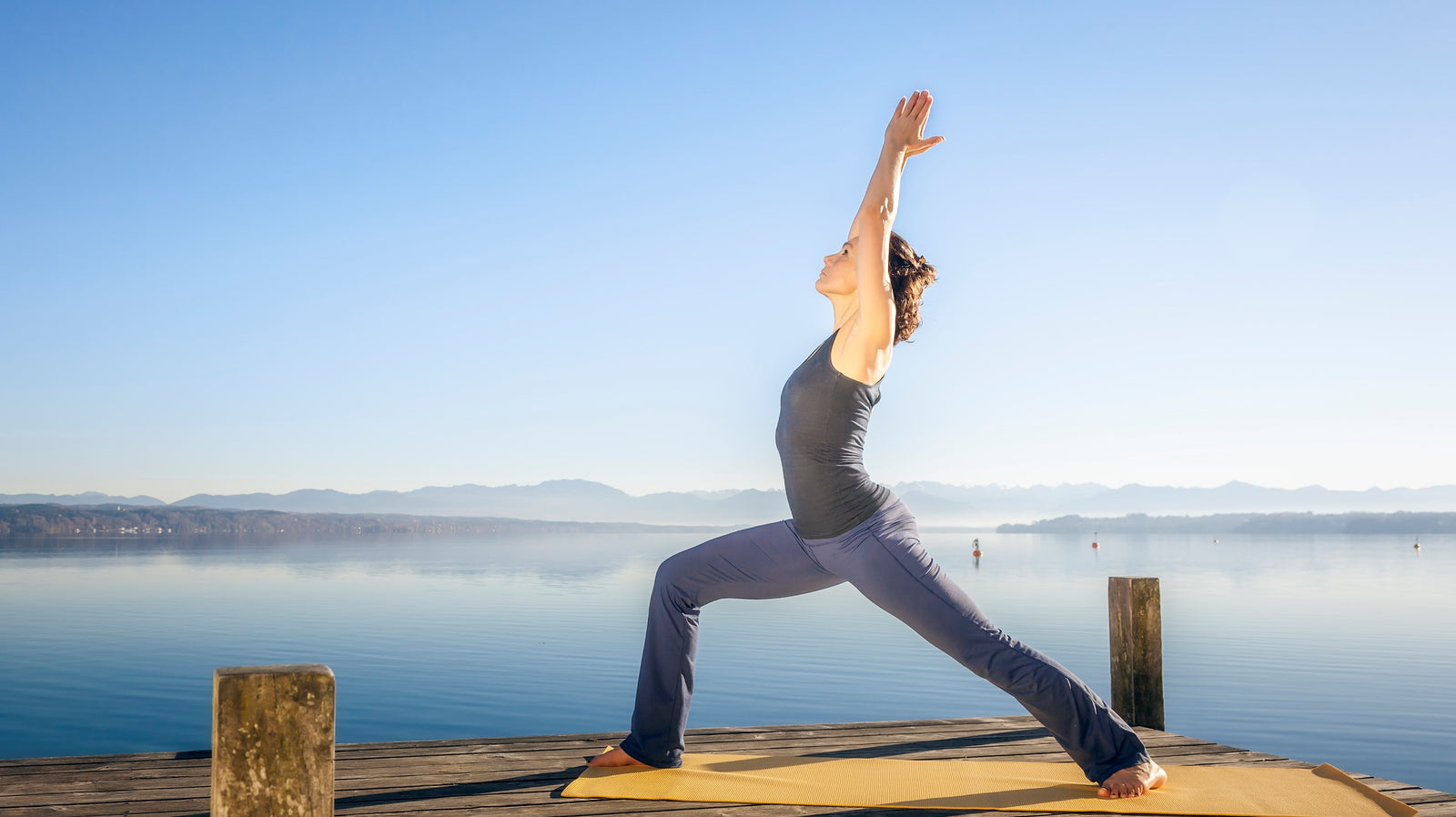 lady performing the yoga posture, asana, virabhdrasana 1, warrior one pose