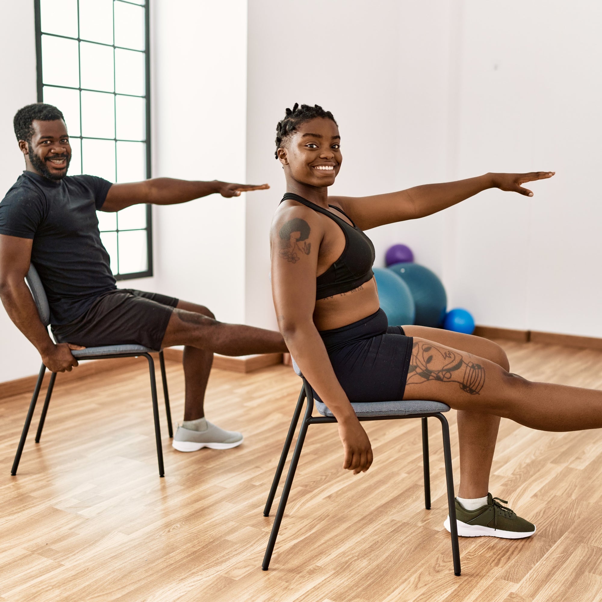 Man and lady practicing chair yoga