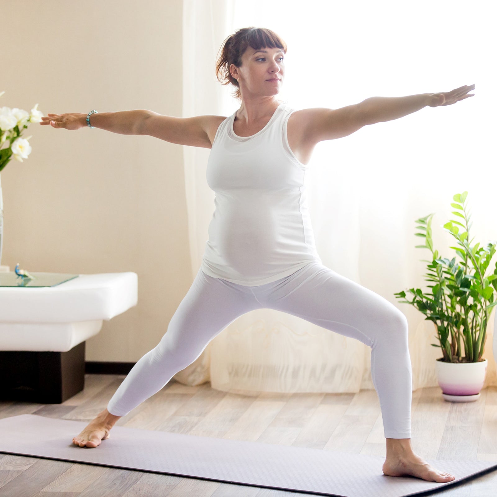 Pregnant yoga student performing Warrior 1