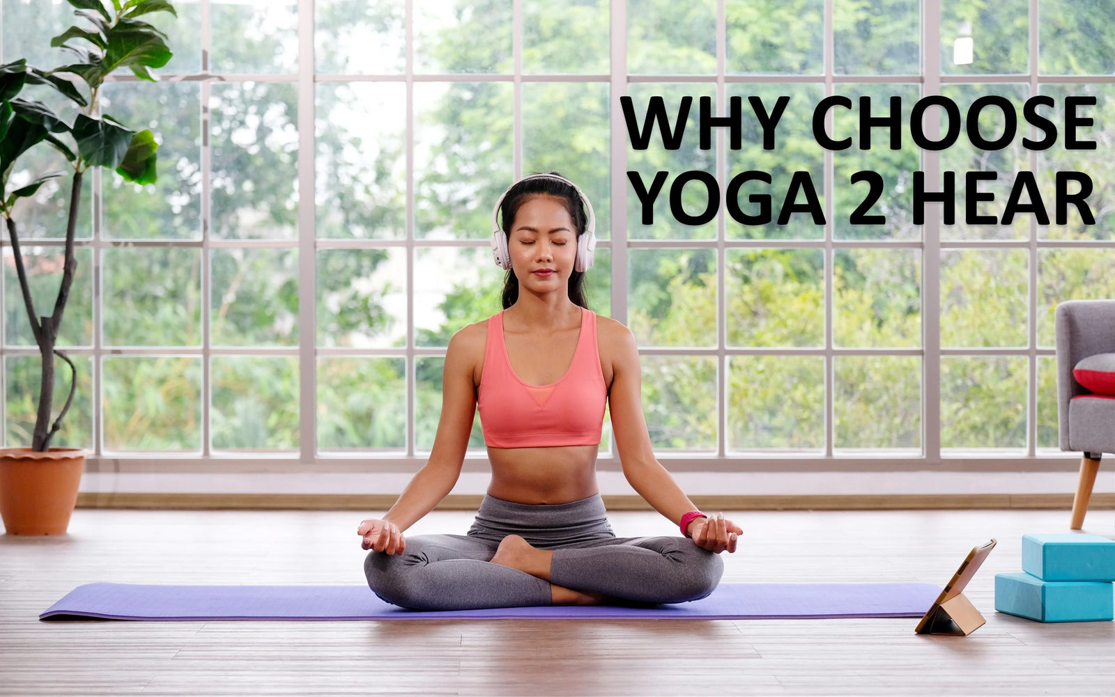 Lady on a yoga mat in front of a window in the yoga pose half lotus, ardha padmasana