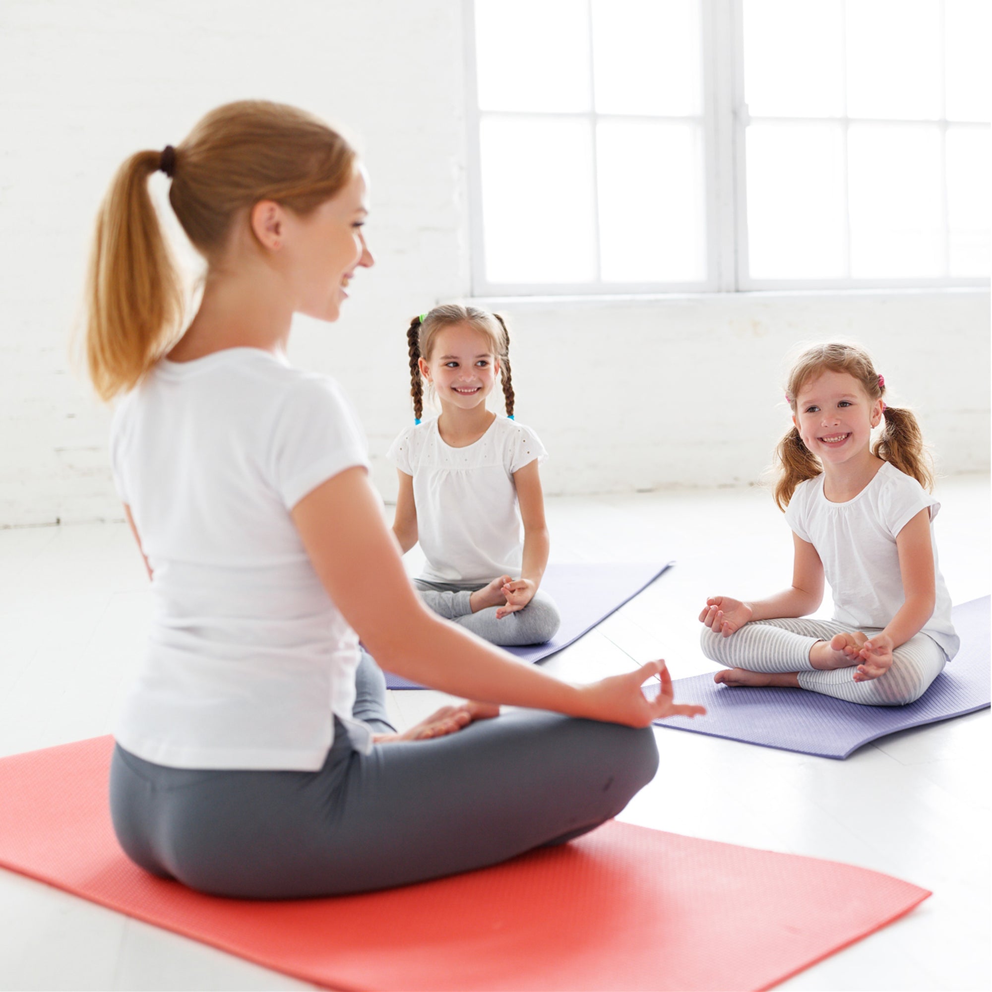 yoga teacher instructing children